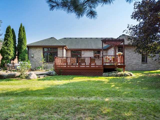 rear view of property with a yard, a pergola, and a deck