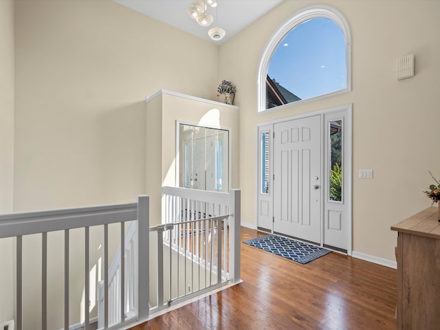 entrance foyer featuring hardwood / wood-style floors and a towering ceiling