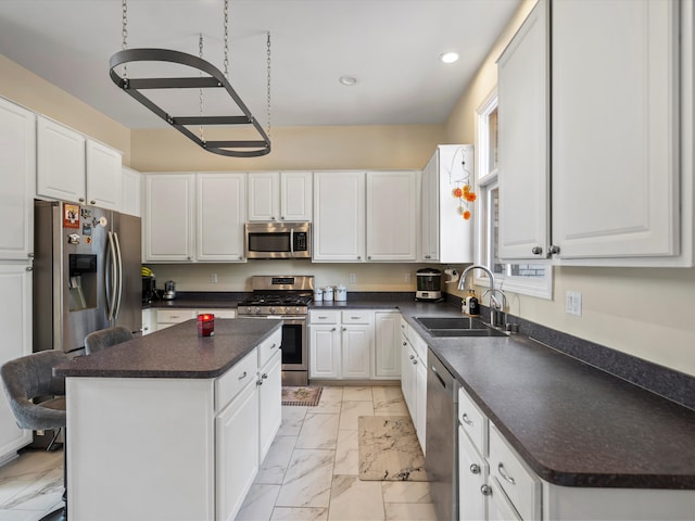 kitchen featuring a kitchen island, white cabinetry, sink, and appliances with stainless steel finishes