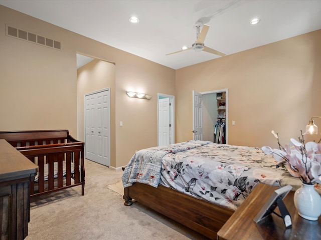 bedroom with ceiling fan, a closet, and light colored carpet