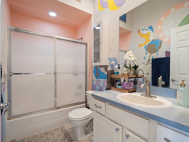 full bathroom featuring combined bath / shower with glass door, vanity, toilet, and tile patterned flooring