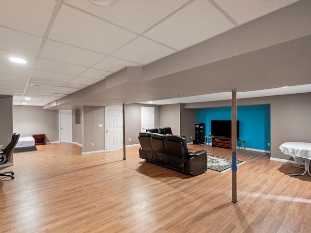 living room with a drop ceiling and light hardwood / wood-style flooring