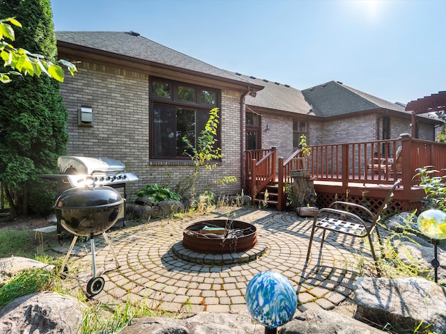 view of patio / terrace with a deck and an outdoor fire pit