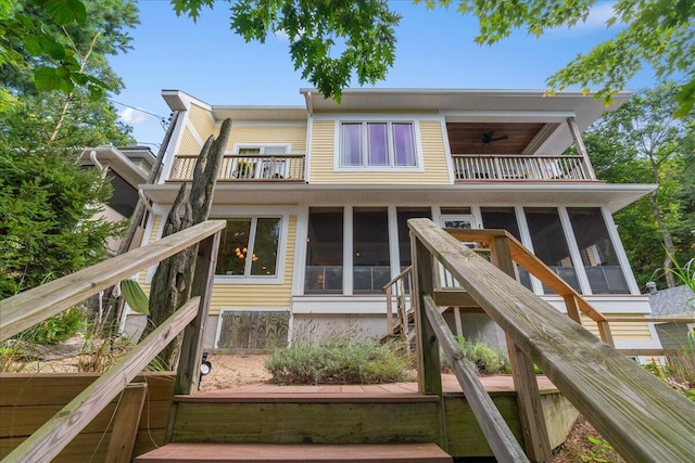 876 S Beach, Pentwater, MI 49449 - rear view of house featuring a balcony, a sunroom, and stairway