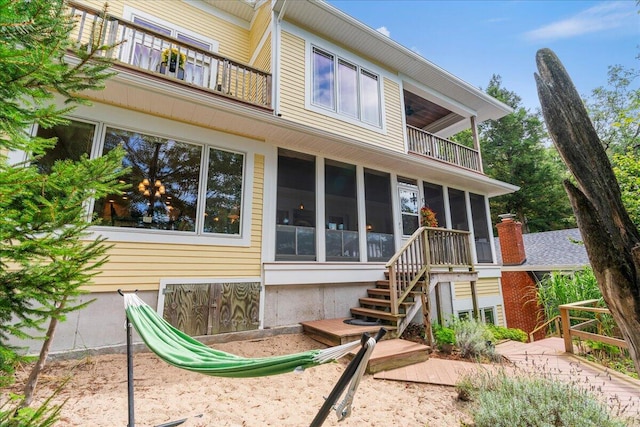 876 S Beach, Pentwater, MI 49449 - back of house featuring a balcony, a sunroom, and stairway
