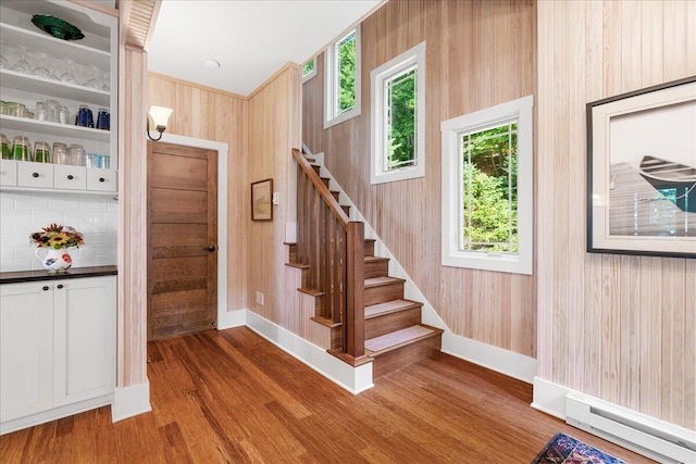876 S Beach, Pentwater, MI 49449 - stairway with baseboard heating, wood finished floors, baseboards, and wooden walls