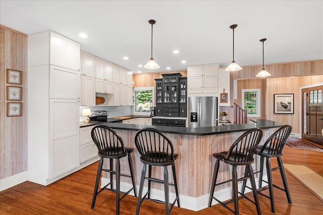 876 S Beach, Pentwater, MI 49449 - kitchen with appliances with stainless steel finishes, dark countertops, glass insert cabinets, a spacious island, and a kitchen breakfast bar