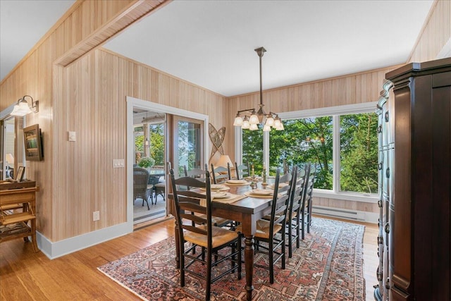 876 S Beach, Pentwater, MI 49449 - dining room featuring a chandelier, light wood-style flooring, wooden walls, and baseboards