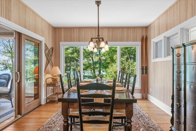 876 S Beach, Pentwater, MI 49449 - dining room with healthy amount of natural light, light wood-style floors, a chandelier, french doors, and crown molding