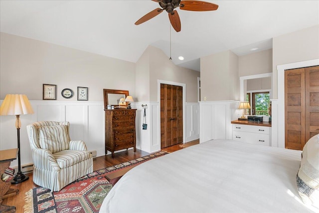 876 S Beach, Pentwater, MI 49449 - bedroom featuring wood finished floors, a wainscoted wall, a decorative wall, a ceiling fan, and vaulted ceiling