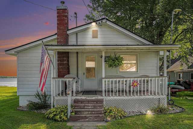 76 Sundago Park St, Hastings, MI 49058 - view of front of house with covered porch, a chimney, and a front lawn