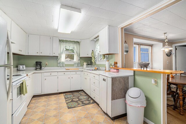 76 Sundago Park St, Hastings, MI 49058 - kitchen featuring white appliances, light countertops, white cabinets, and a peninsula