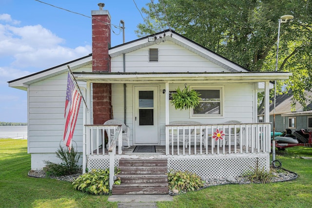 76 Sundago Park St, Hastings, MI 49058 - view of front of home with covered porch, a front yard, and a chimney