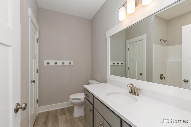 bathroom featuring a shower, toilet, vanity, and hardwood / wood-style flooring