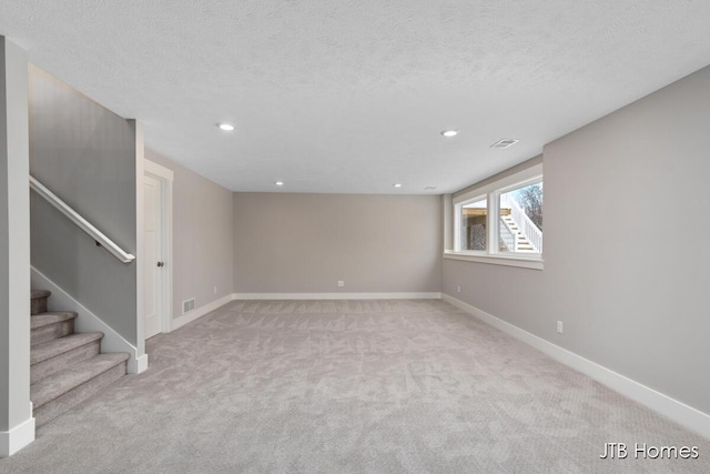 empty room featuring light carpet and a textured ceiling