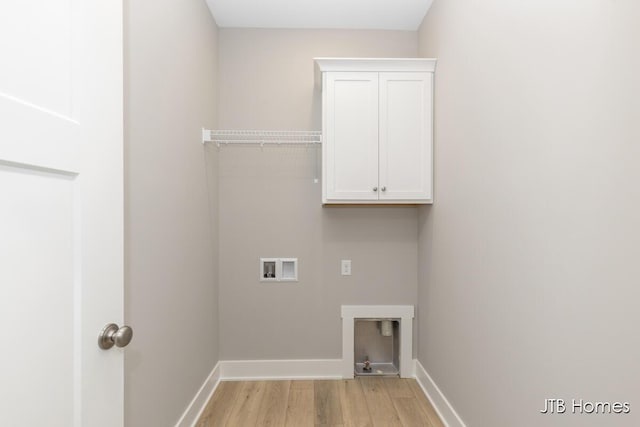 laundry room with light hardwood / wood-style floors, cabinets, and hookup for a washing machine