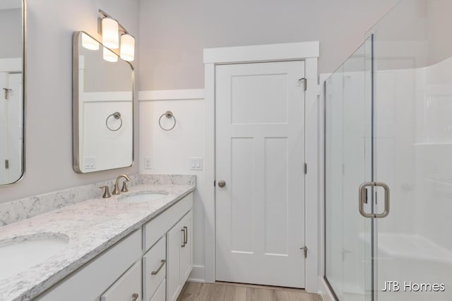 bathroom featuring vanity, an enclosed shower, and wood-type flooring