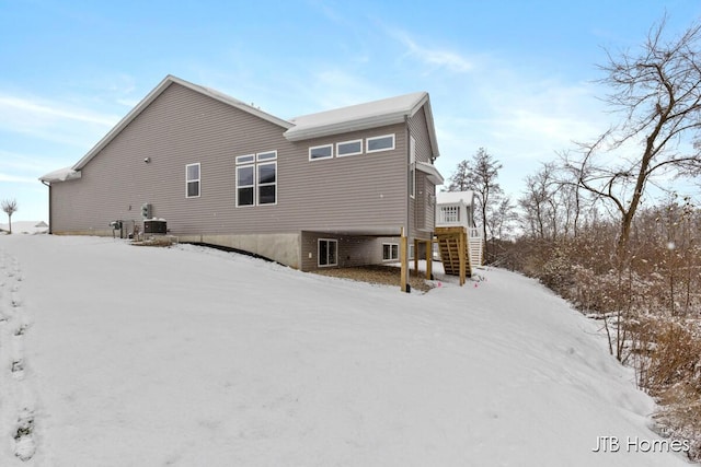 snow covered back of property with cooling unit