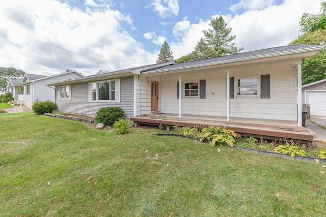 view of front of home with an outbuilding, a front yard, and a garage