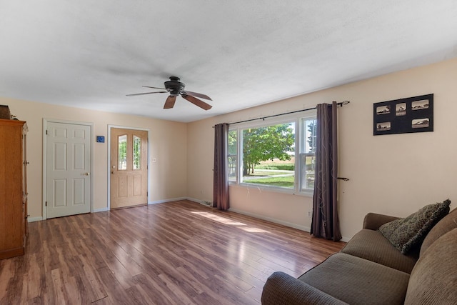 unfurnished living room featuring a wealth of natural light, ceiling fan, and wood-type flooring