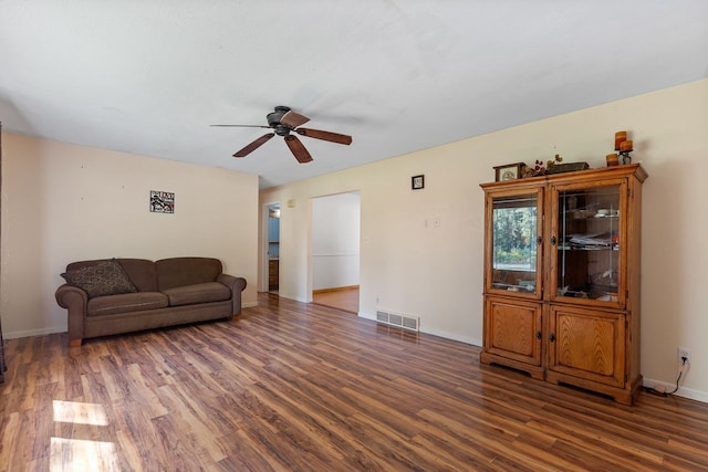 living room featuring ceiling fan and dark wood-type flooring