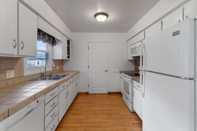 kitchen featuring white cabinetry, white appliances, sink, and light hardwood / wood-style flooring