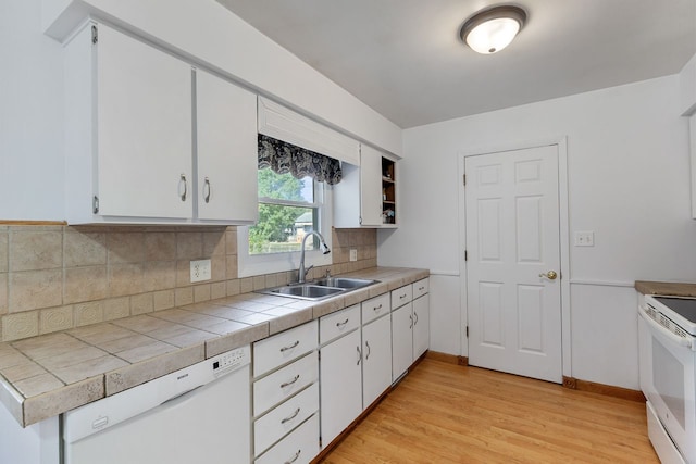 kitchen with white cabinetry, sink, light hardwood / wood-style flooring, tile countertops, and white appliances