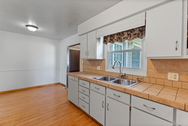 kitchen with dishwasher, decorative backsplash, white cabinetry, and sink