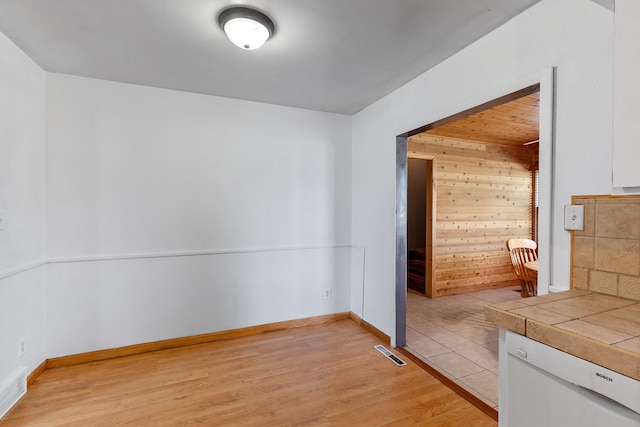 interior space featuring light hardwood / wood-style floors and wood walls