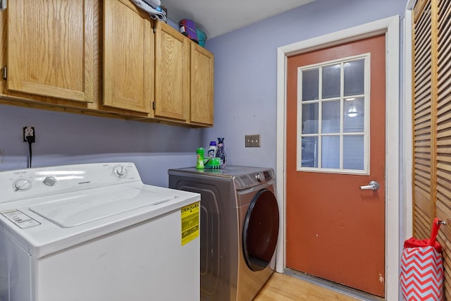 washroom featuring cabinets, independent washer and dryer, and light wood-type flooring