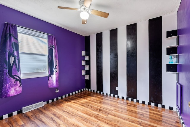 unfurnished room featuring ceiling fan, a textured ceiling, and hardwood / wood-style flooring