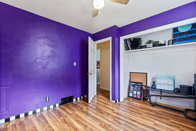 interior space with wood-type flooring and ceiling fan