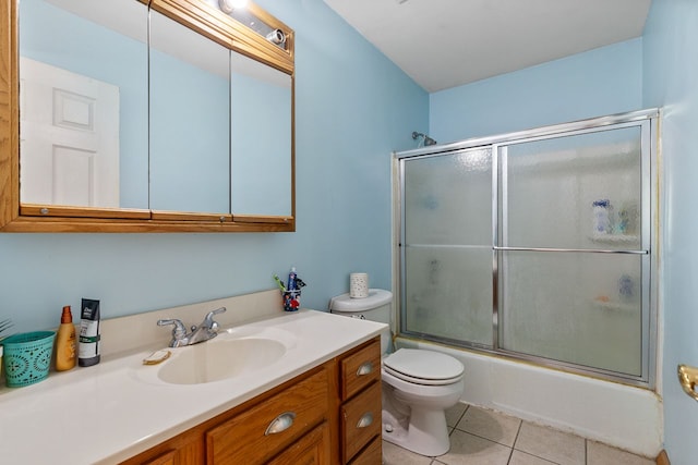 full bathroom with shower / bath combination with glass door, vanity, tile patterned floors, and toilet