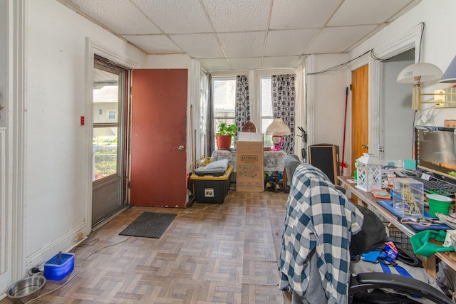 misc room with a drop ceiling and parquet flooring