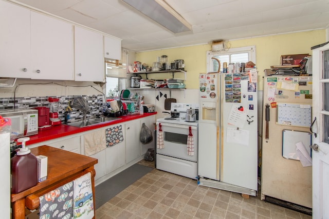 kitchen with white appliances, white cabinetry, and sink