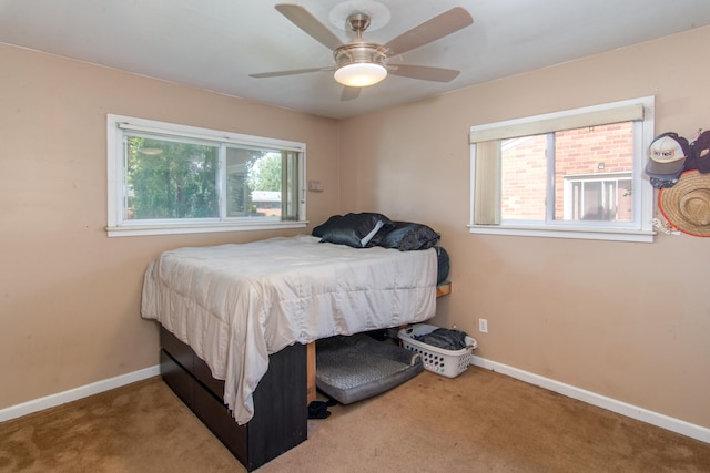 carpeted bedroom featuring multiple windows and ceiling fan