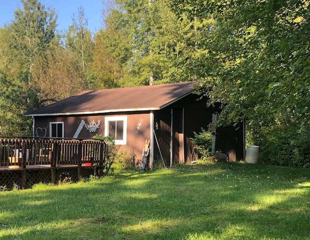 back of property featuring a deck and a lawn