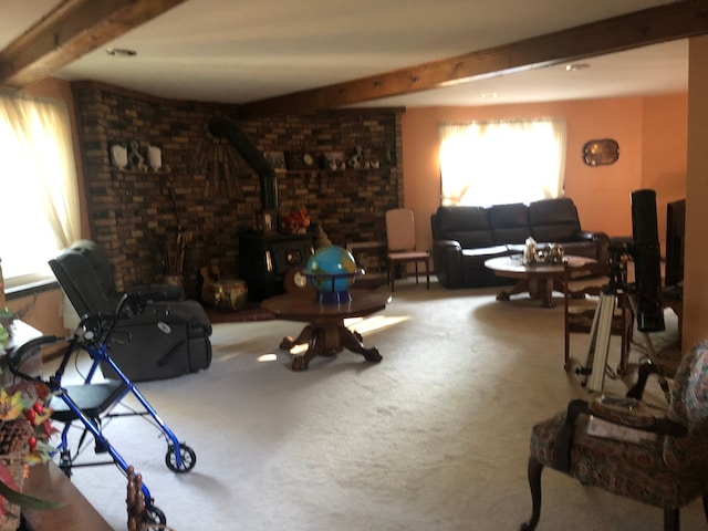 living room with carpet flooring, a wood stove, and beamed ceiling