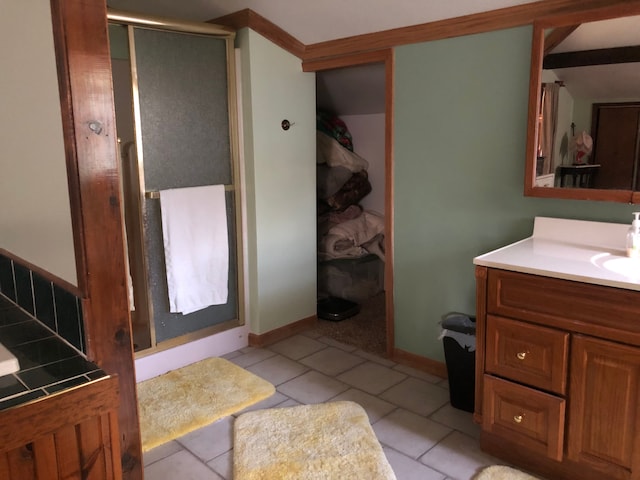 bathroom featuring tile patterned flooring, vanity, and a shower with door