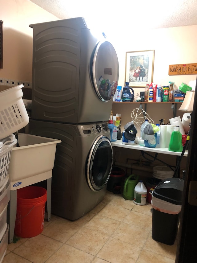 washroom featuring light tile patterned floors and stacked washer / drying machine