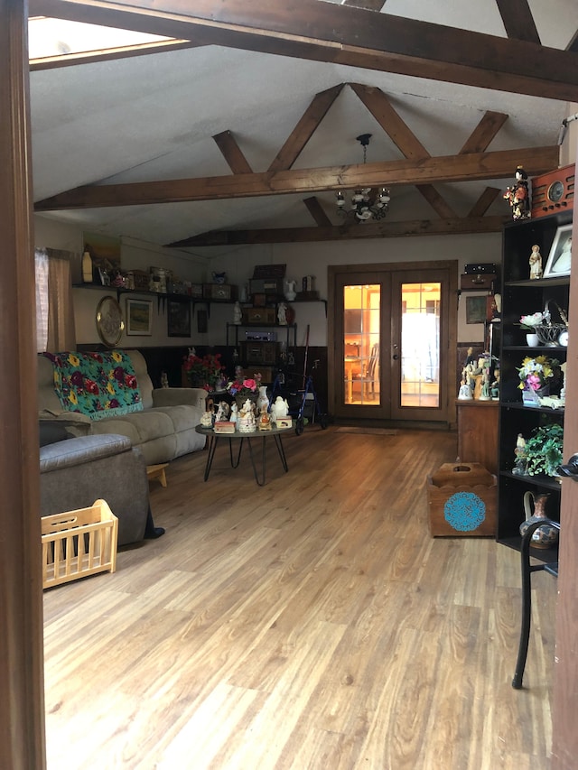 living room featuring french doors, lofted ceiling with beams, and wood-type flooring