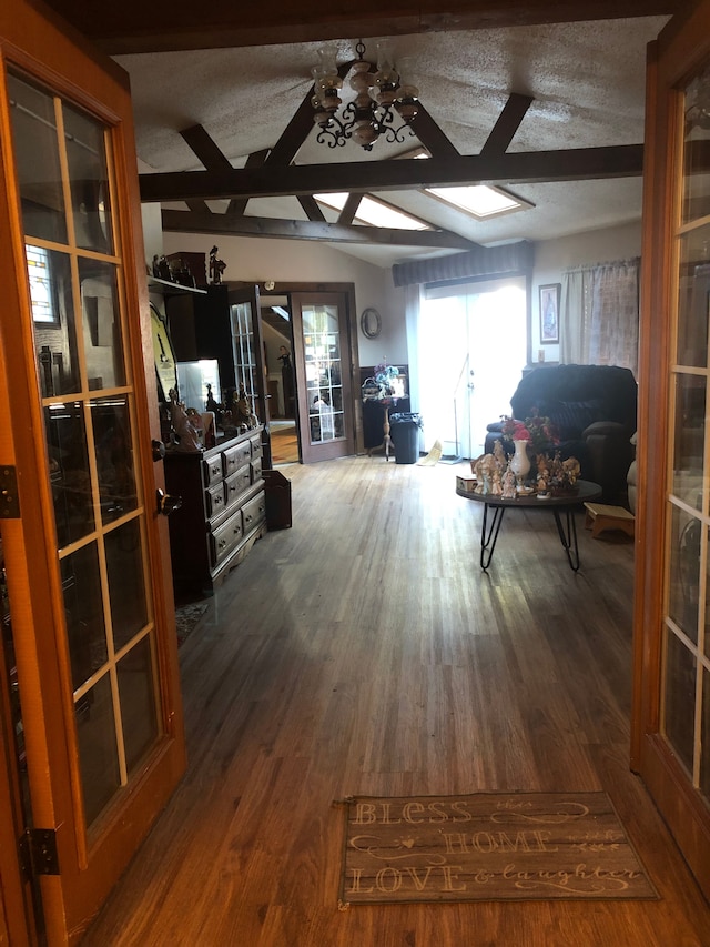 interior space with a textured ceiling, beam ceiling, and dark hardwood / wood-style floors