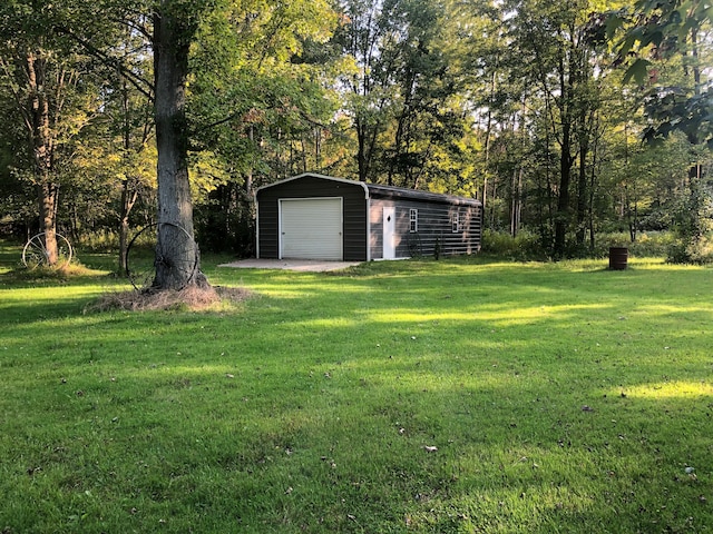 view of yard featuring a garage and an outbuilding