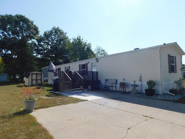 view of front of house with a storage unit and a front yard