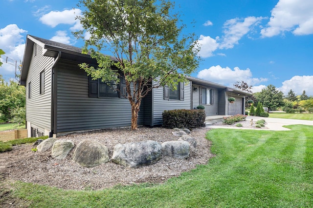 ranch-style home featuring a front lawn and a garage