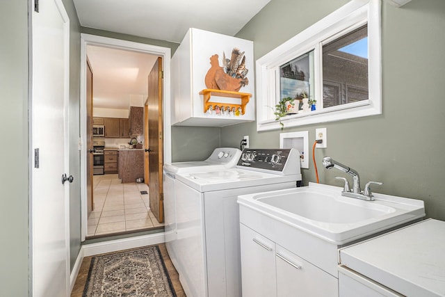 clothes washing area featuring separate washer and dryer, sink, cabinets, and tile patterned flooring