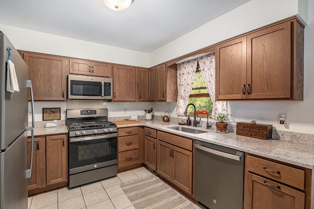 kitchen featuring light tile patterned floors, stainless steel appliances, and sink