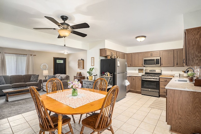 dining space featuring light tile patterned floors, ceiling fan, and sink