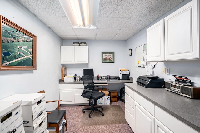 home office with a drop ceiling and built in desk