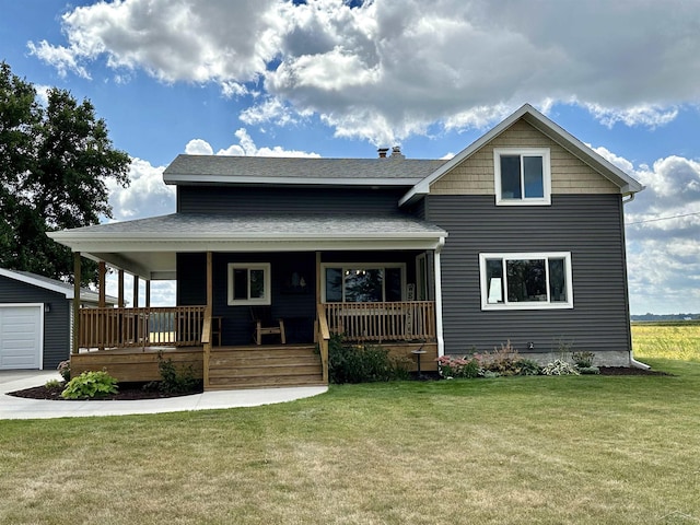 view of front of home with a garage, a porch, an outbuilding, and a front lawn